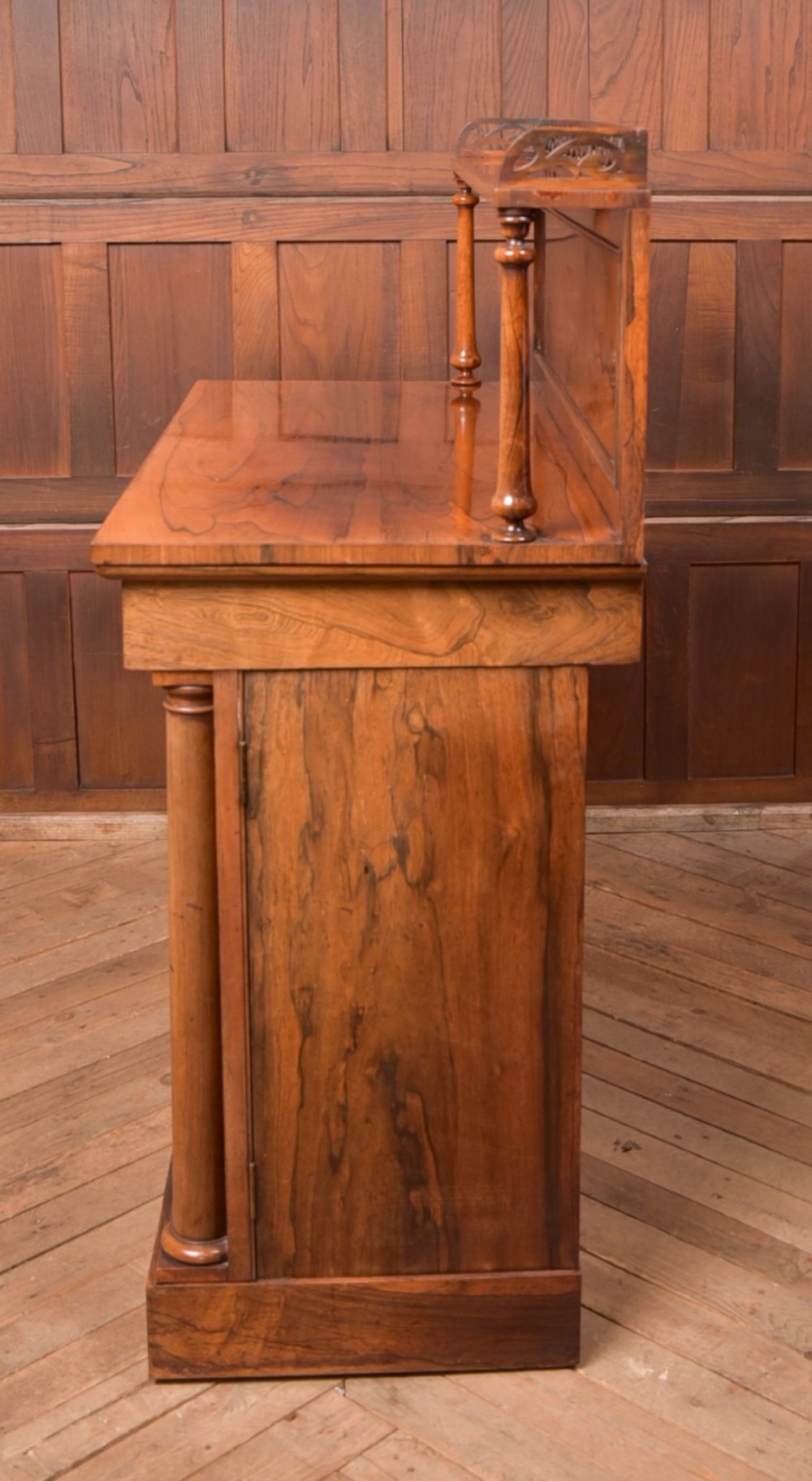 A Victorian rosewood chiffonier side cabinet featuring a raised back shelf with open fretwork gallery, turned columns, and a double-door cupboard base. View V