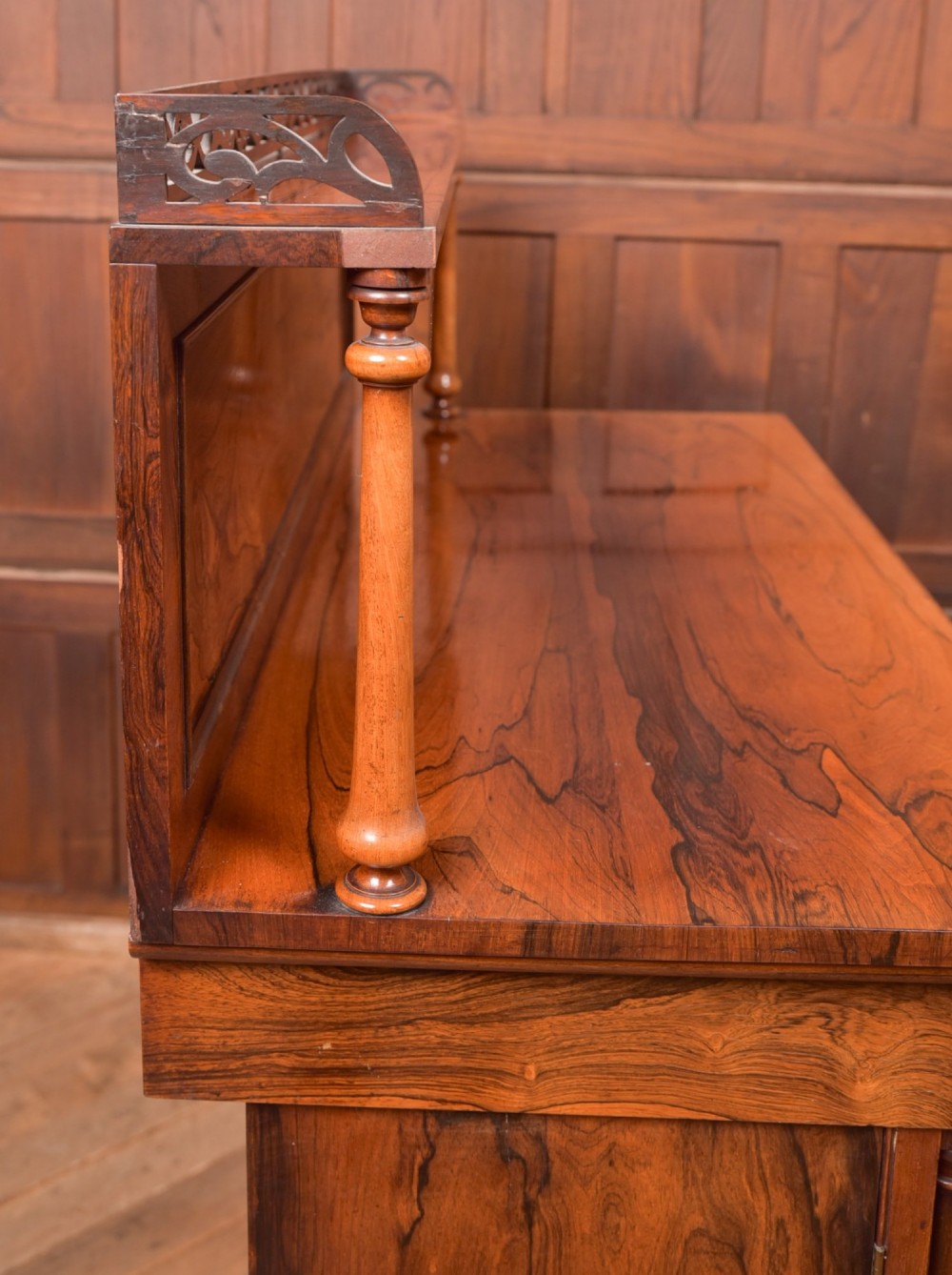 A Victorian rosewood chiffonier side cabinet featuring a raised back shelf with open fretwork gallery, turned columns, and a double-door cupboard base. View VI