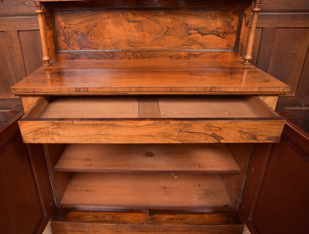 A Victorian rosewood chiffonier side cabinet featuring a raised back shelf with open fretwork gallery, turned columns, and a double-door cupboard base. View IX