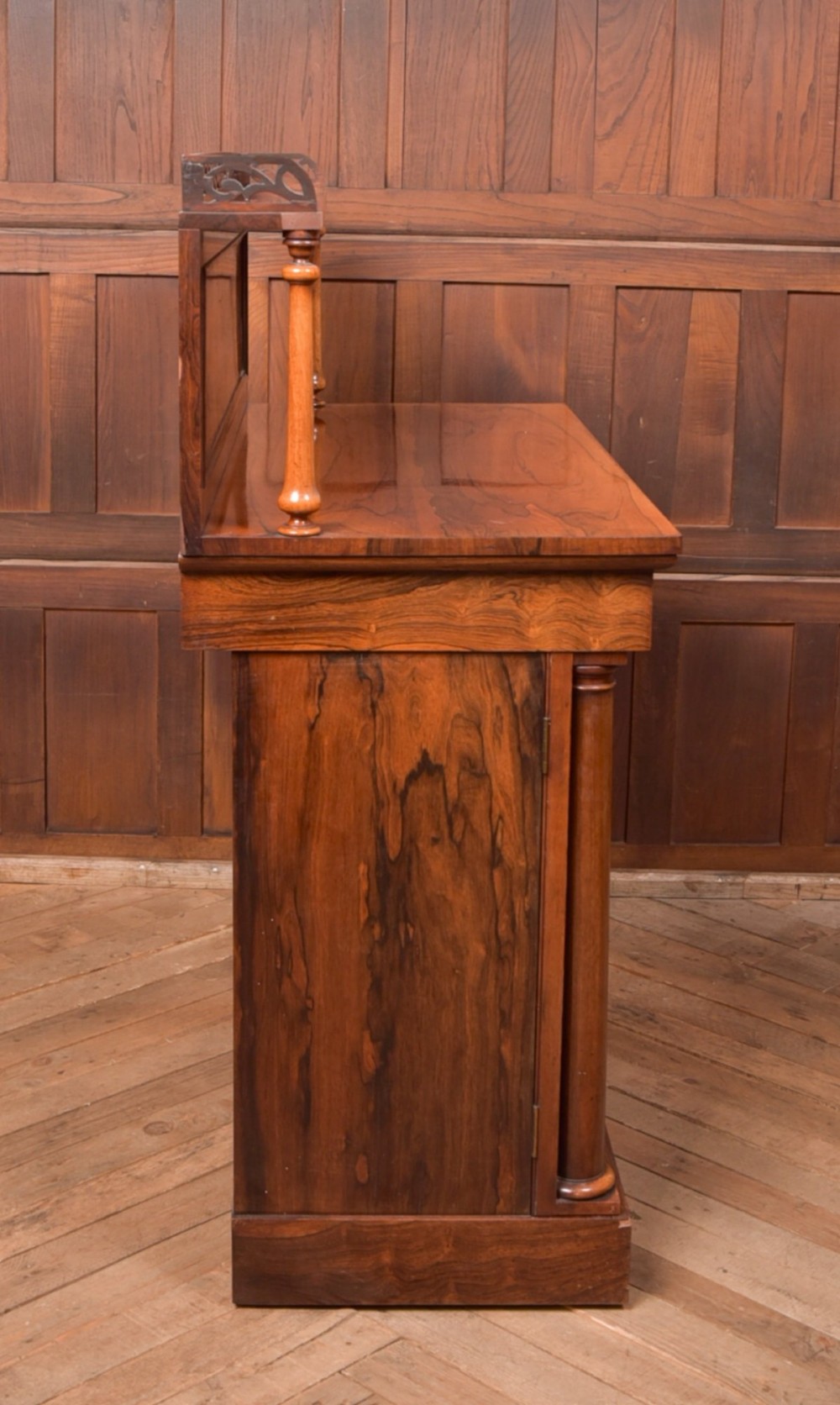 A Victorian rosewood chiffonier side cabinet featuring a raised back shelf with open fretwork gallery, turned columns, and a double-door cupboard base. View X