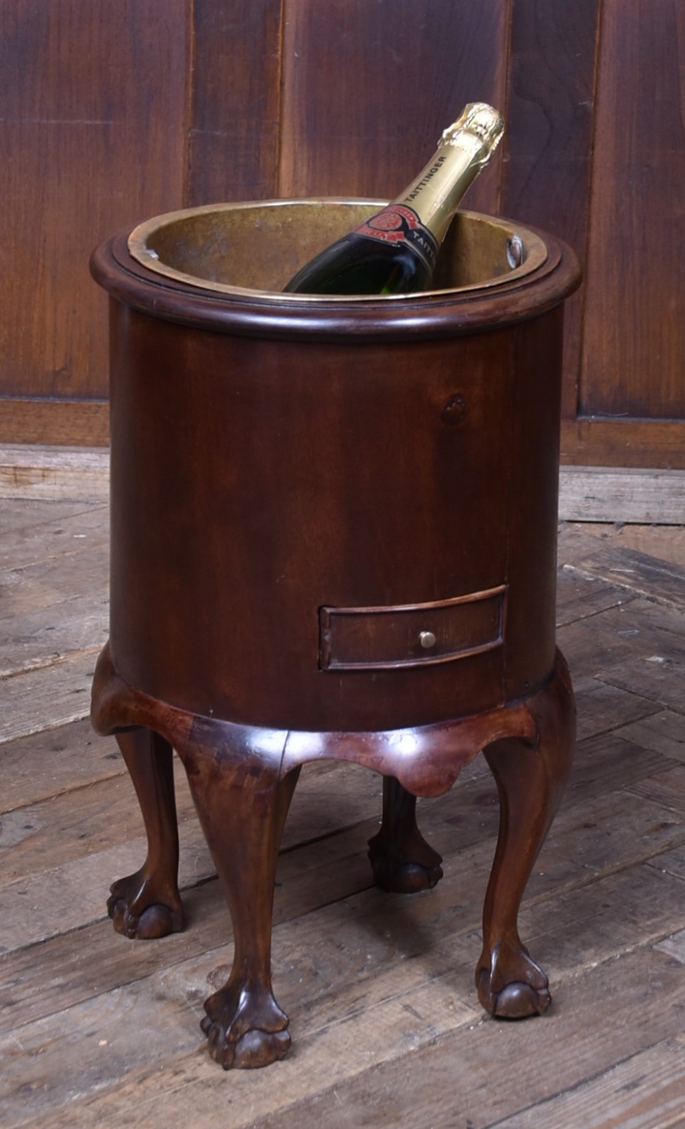 A cylindrical dark mahogany Victorian wine cooler with an internal brass liner, standing on four cabriole legs with ball and claw feet. View II