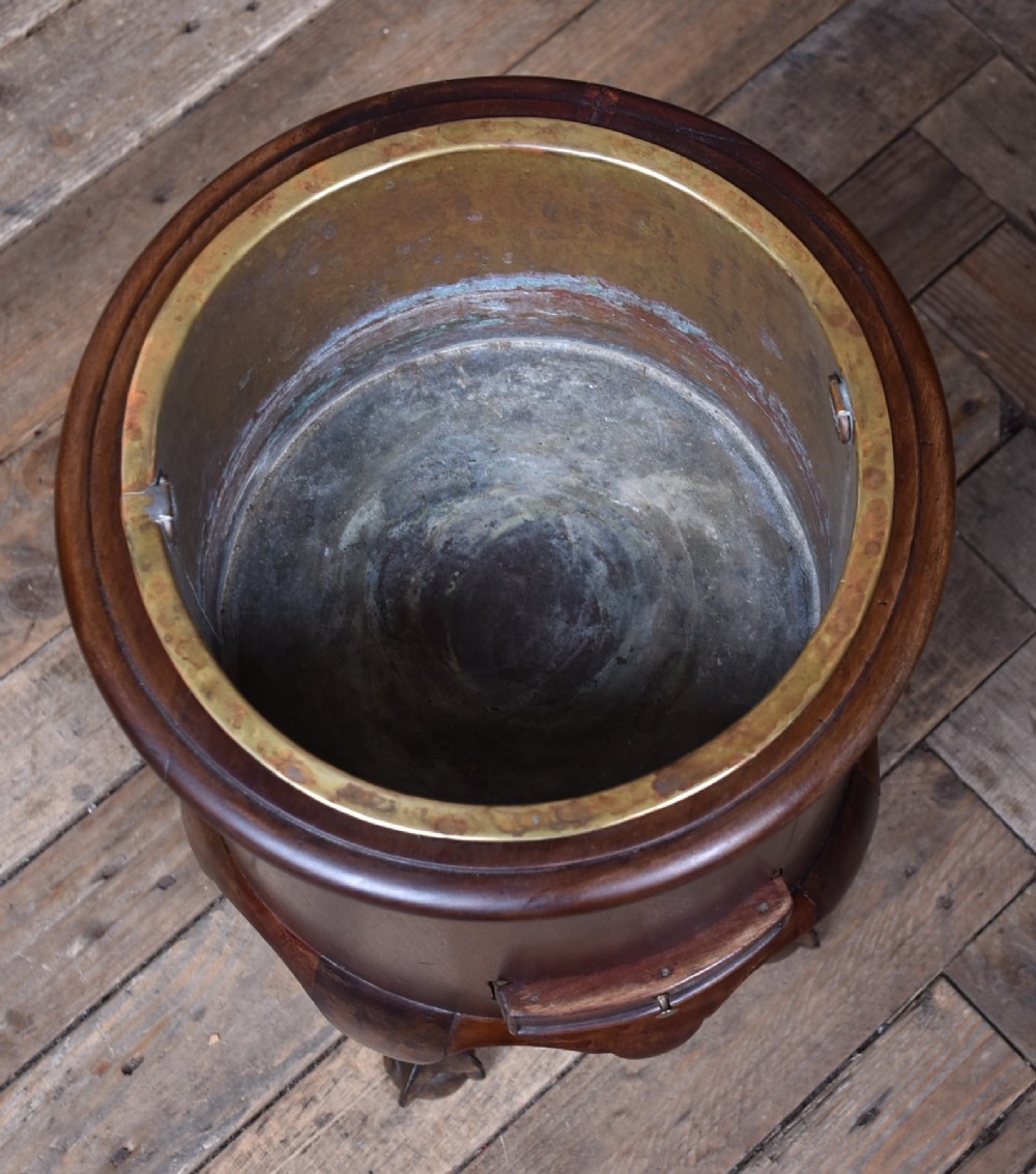 A cylindrical dark mahogany Victorian wine cooler with an internal brass liner, standing on four cabriole legs with ball and claw feet. View VI