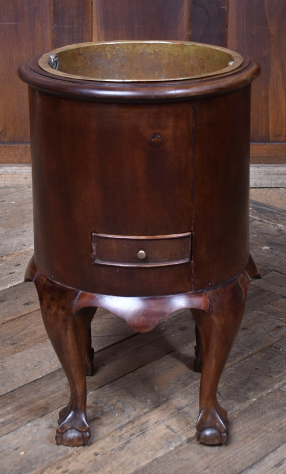 A cylindrical dark mahogany Victorian wine cooler with an internal brass liner, standing on four cabriole legs with ball and claw feet. View VII