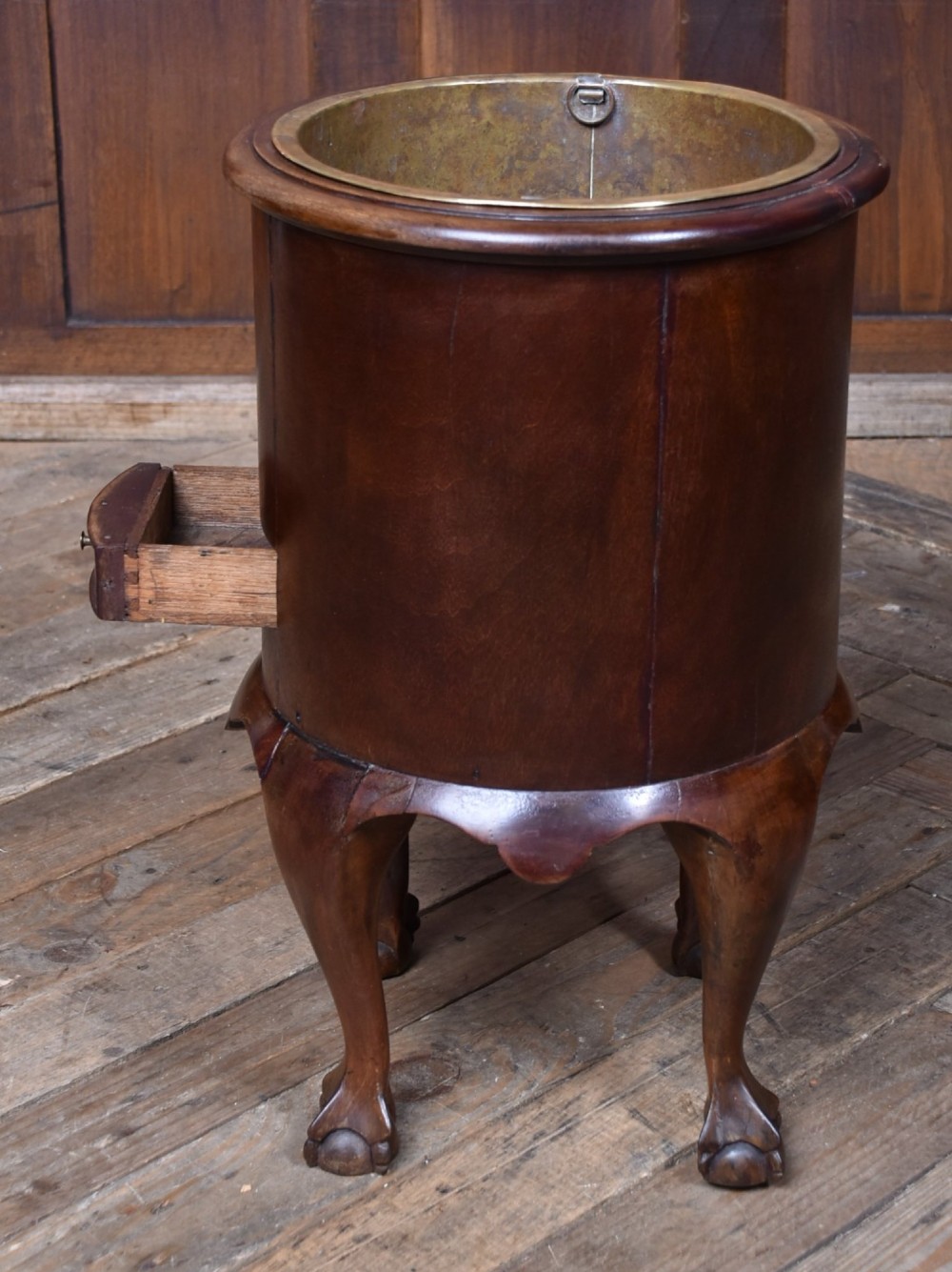 A cylindrical dark mahogany Victorian wine cooler with an internal brass liner, standing on four cabriole legs with ball and claw feet. View X