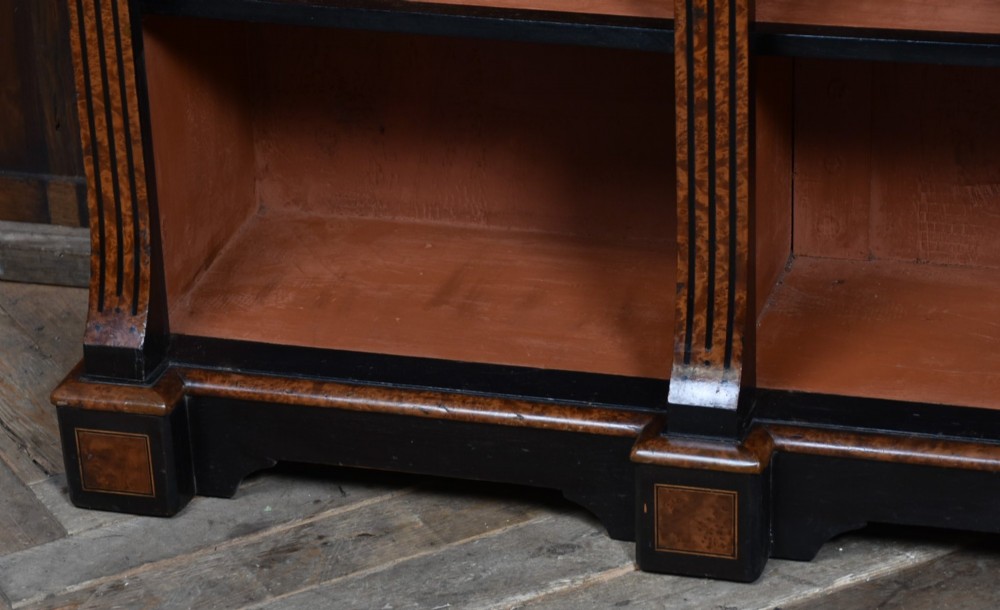 A low Victorian open bookcase featuring three sections of open shelving, rich amboyna wood veneer, ebonised borders, and delicate marquetry inlays. View VII