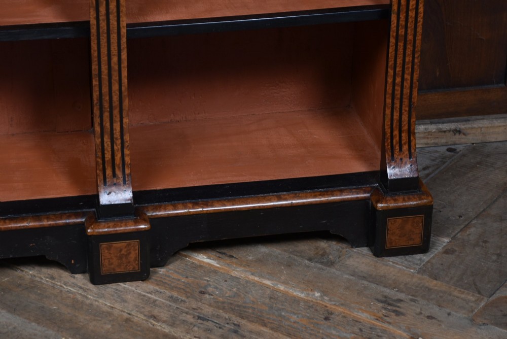 A low Victorian open bookcase featuring three sections of open shelving, rich amboyna wood veneer, ebonised borders, and delicate marquetry inlays. View VIII
