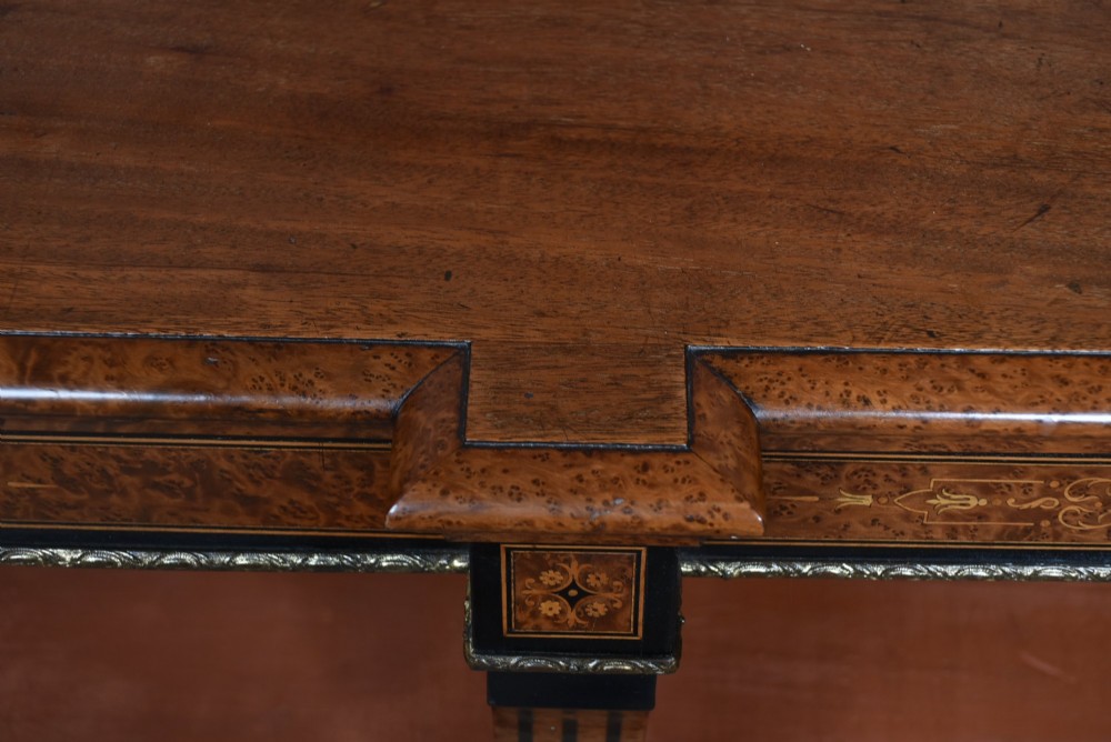 A low Victorian open bookcase featuring three sections of open shelving, rich amboyna wood veneer, ebonised borders, and delicate marquetry inlays. View XI