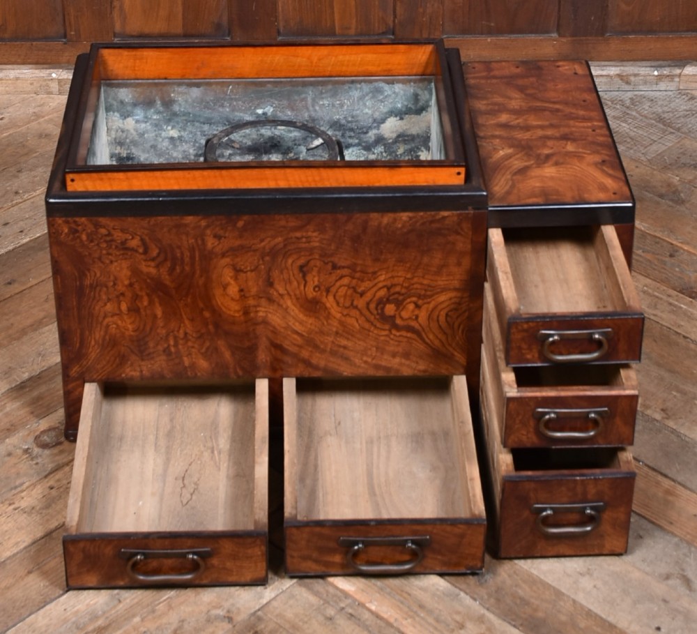 A traditional Japanese wooden hibachi brazier featuring rich figured wood grain, a copper-lined inner well, multiple small drawers, and iron bail handles. View V
