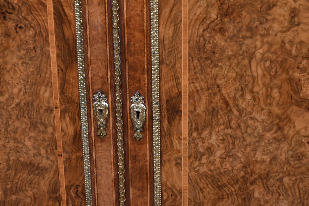 A 19th-century Victorian burr walnut side cabinet featuring two panelled doors with decorative brass mounts and a plinth base. View IV