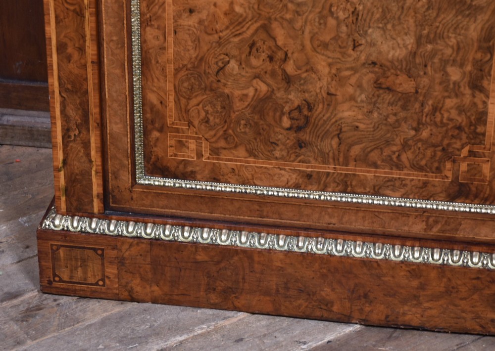 A 19th-century Victorian burr walnut side cabinet featuring two panelled doors with decorative brass mounts and a plinth base. View VI