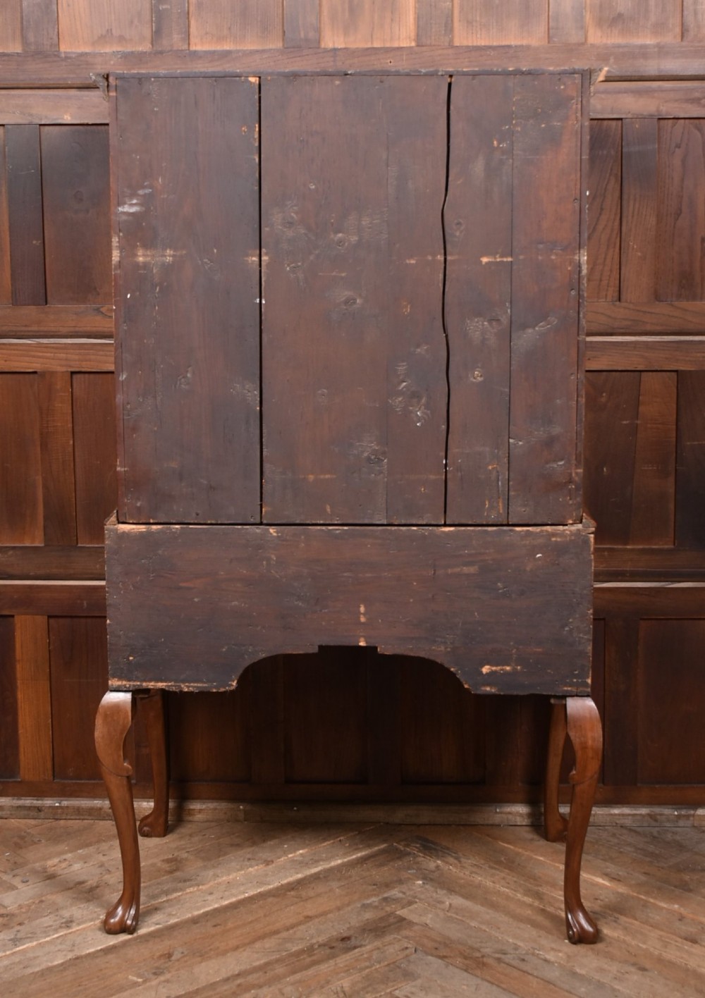 An eighteenth-century figured walnut chest on stand featuring brass hardware, crossbanded drawers, an arched apron, and cabriole legs. View X