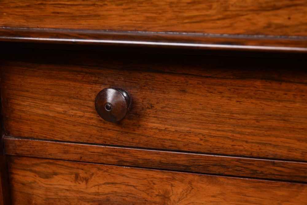 A tall Victorian rosewood Wellington chest featuring six graduated drawers with turned wooden knobs, carved corbels, and a right-side locking bar. View VIII