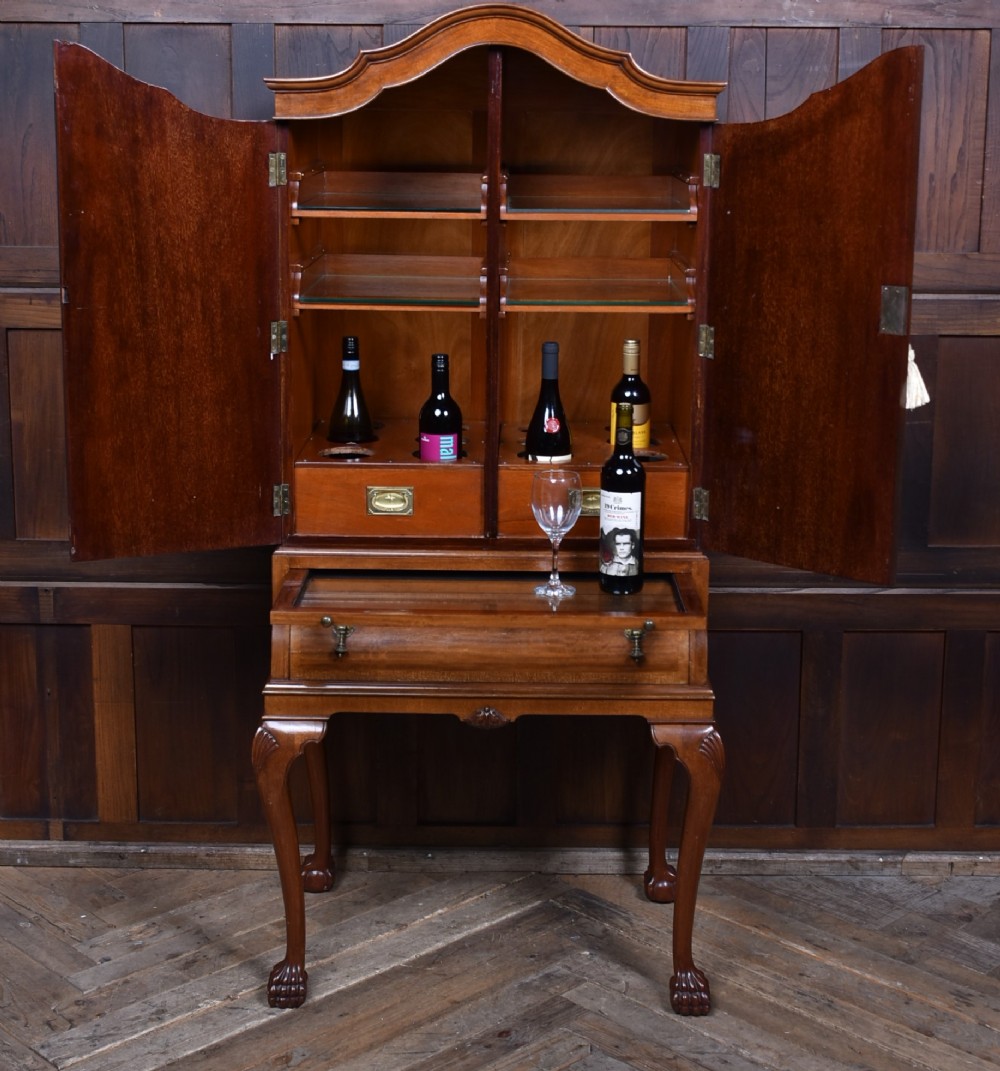 An Edwardian mahogany drinks cabinet on stand featuring chevron-matched wood veneer doors, a lower drawer with brass drop handles, and carved cabriole legs ending in ball and claw feet. View II