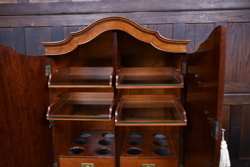 An Edwardian mahogany drinks cabinet on stand featuring chevron-matched wood veneer doors, a lower drawer with brass drop handles, and carved cabriole legs ending in ball and claw feet. View IV