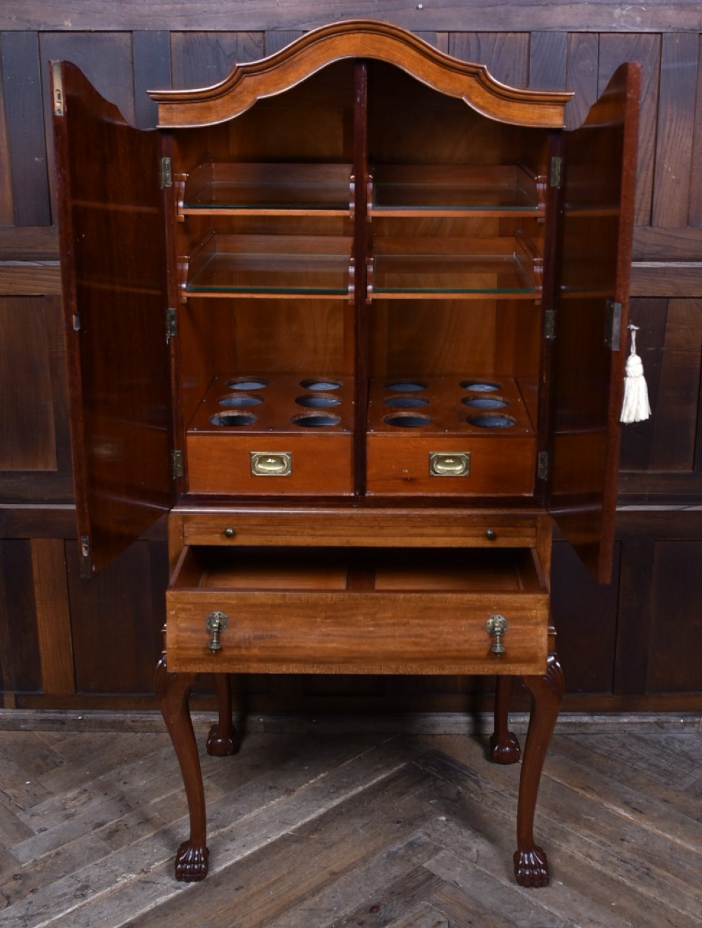An Edwardian mahogany drinks cabinet on stand featuring chevron-matched wood veneer doors, a lower drawer with brass drop handles, and carved cabriole legs ending in ball and claw feet. View VII