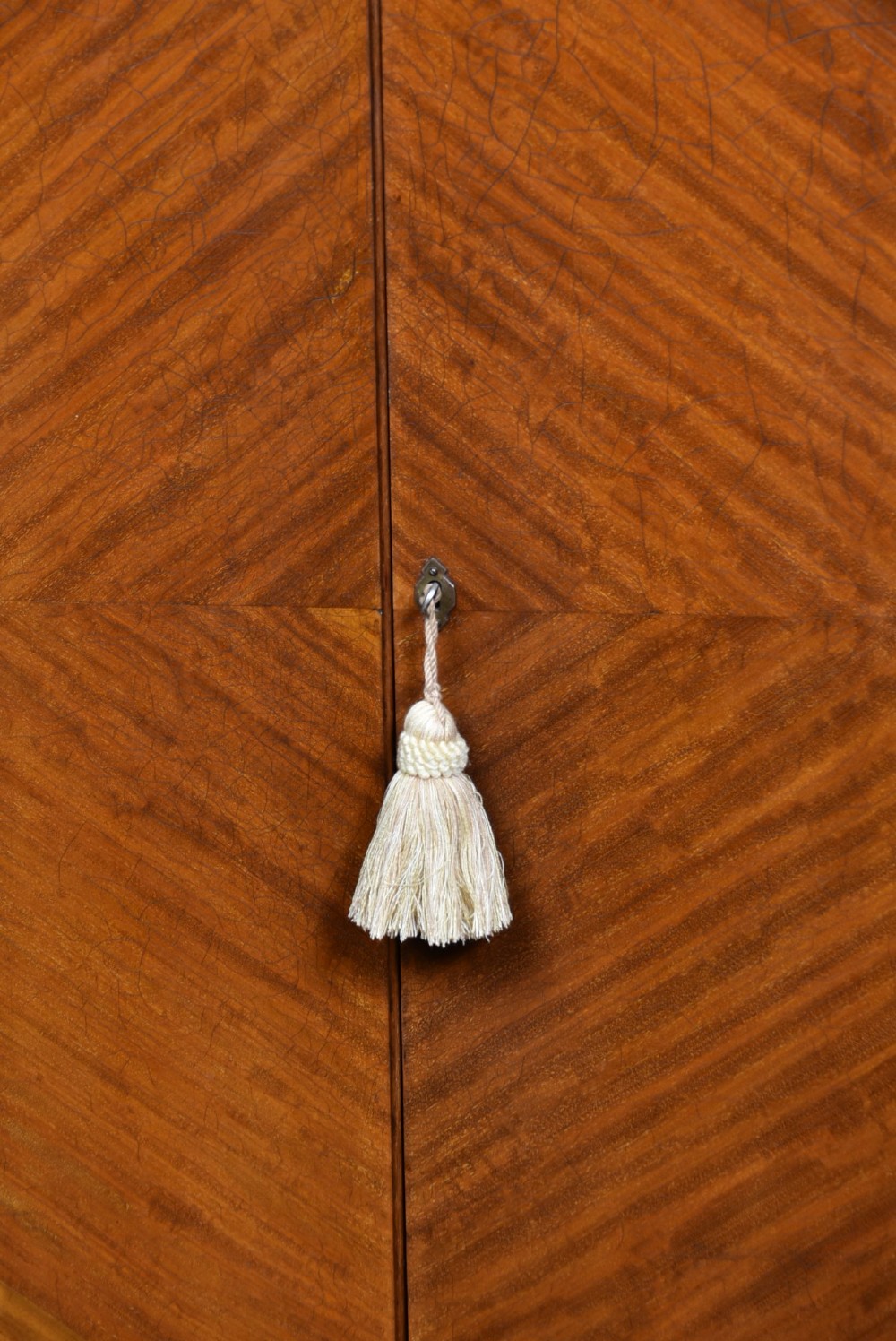 An Edwardian mahogany drinks cabinet on stand featuring chevron-matched wood veneer doors, a lower drawer with brass drop handles, and carved cabriole legs ending in ball and claw feet. View XIII