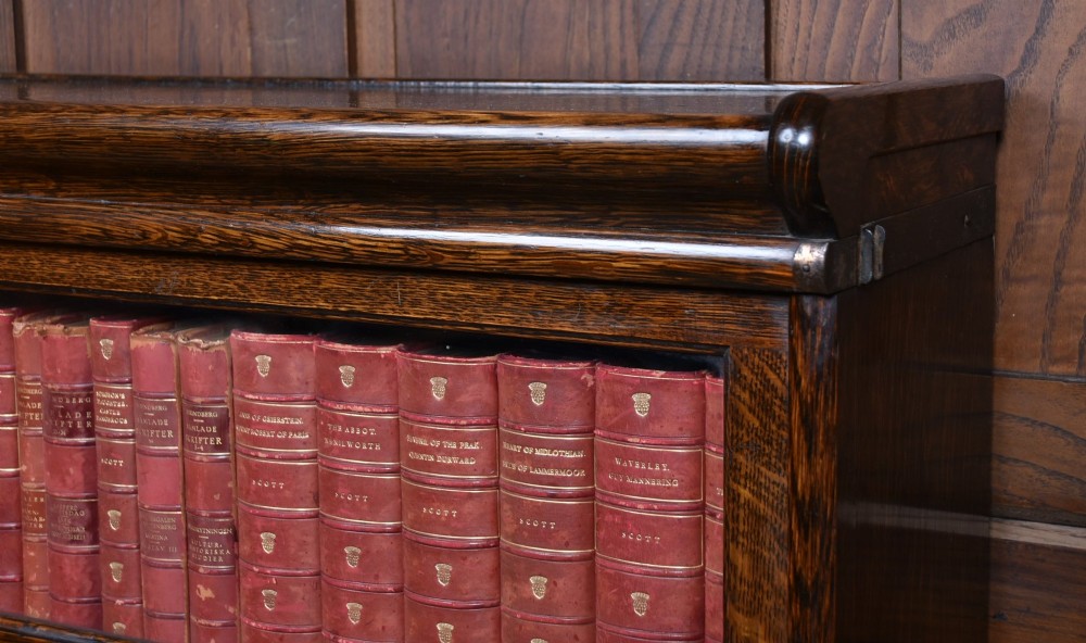 An Edwardian dark oak four-tier Globe Wernicke sectional bookcase featuring glass up-and-over doors and brass maker labels. View III