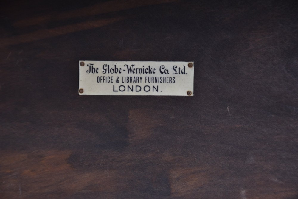 An Edwardian dark oak four-tier Globe Wernicke sectional bookcase featuring glass up-and-over doors and brass maker labels. View VII