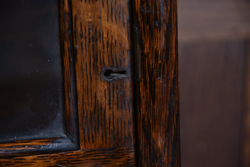 An Edwardian dark oak four-tier Globe Wernicke sectional bookcase featuring glass up-and-over doors and brass maker labels. View VIII