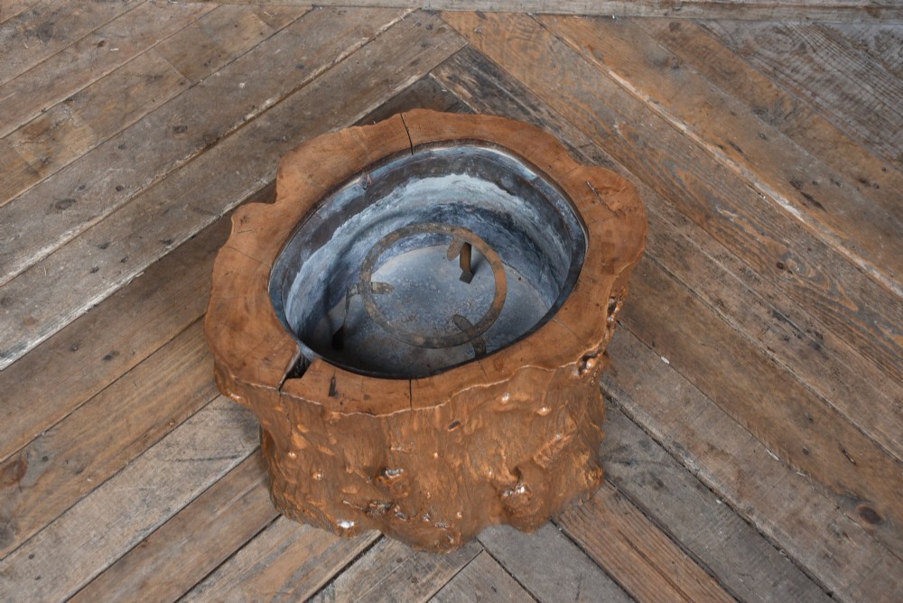 A carved wooden tree-stump hibachi featuring a hollowed centre with a copper lining and iron trivet. View II