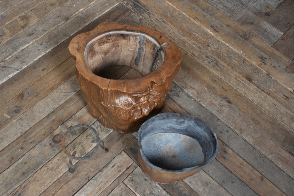 A carved wooden tree-stump hibachi featuring a hollowed centre with a copper lining and iron trivet. View VI