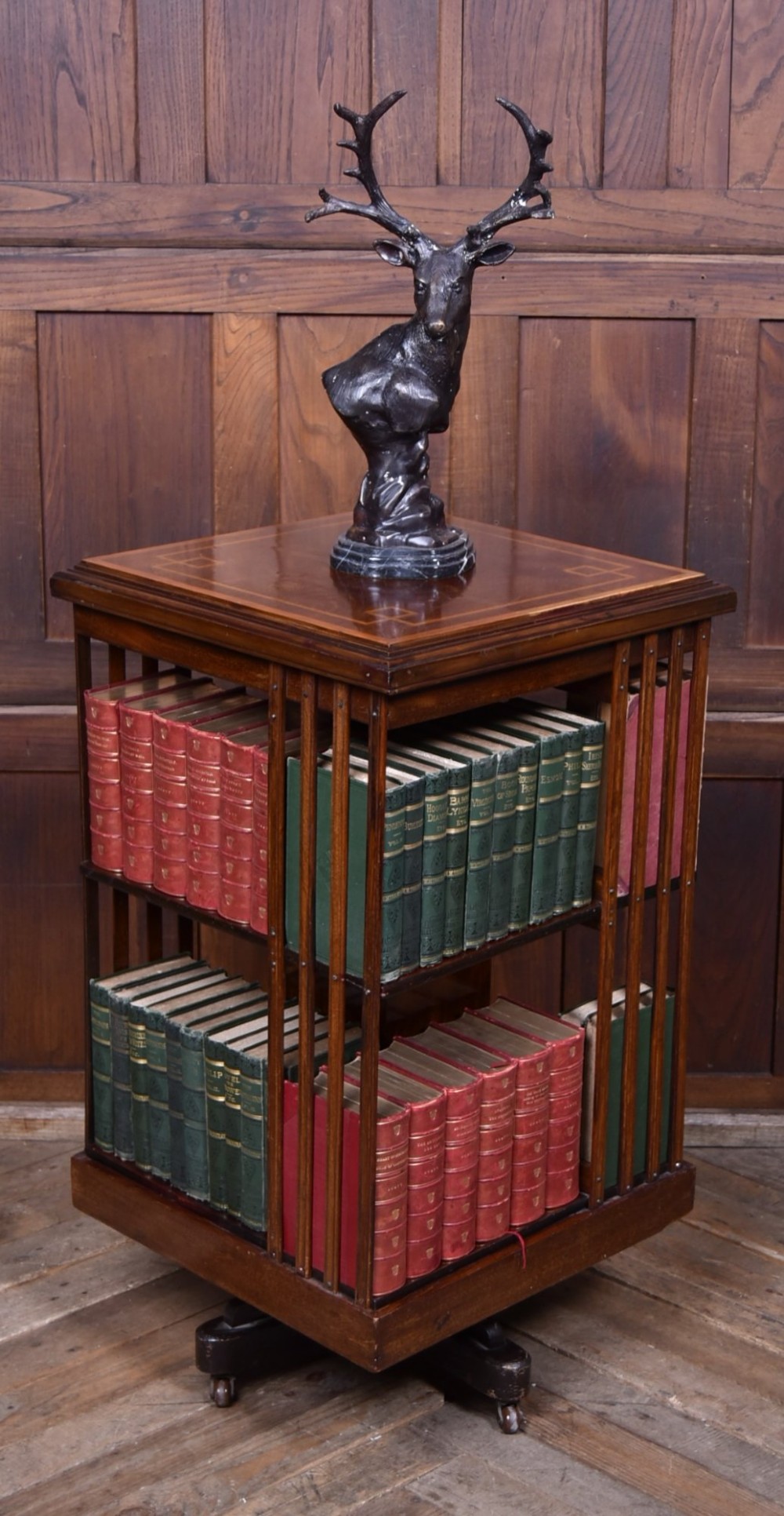 An Edwardian mahogany two-tier revolving bookcase with vertical slatted sides, satinwood top inlay, and a rotating cast-iron base. View II