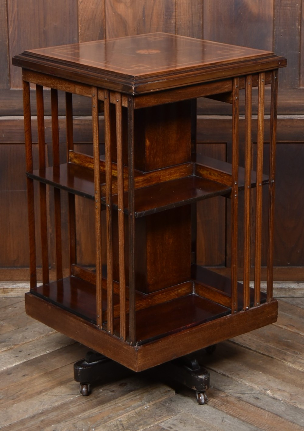 An Edwardian mahogany two-tier revolving bookcase with vertical slatted sides, satinwood top inlay, and a rotating cast-iron base. View IV