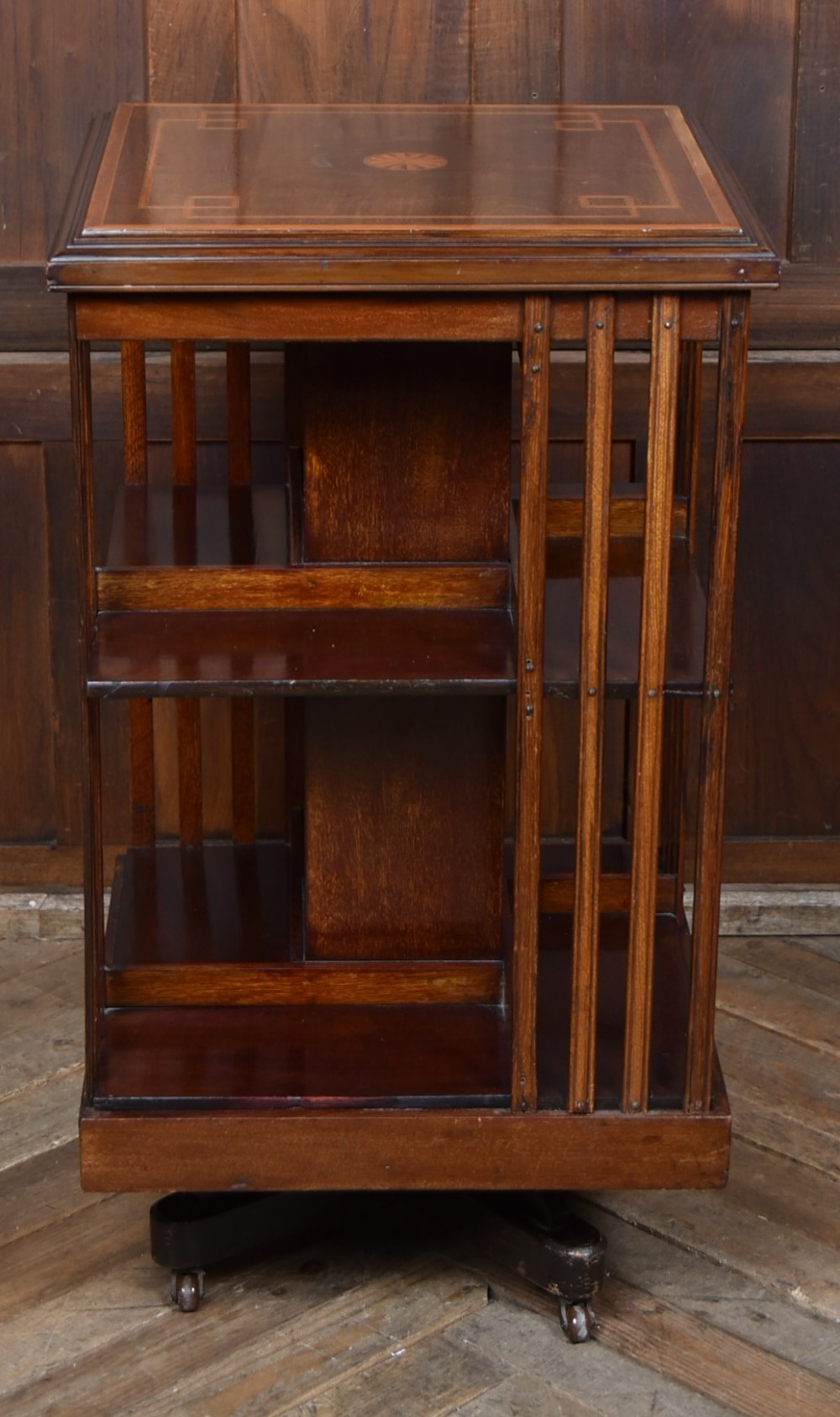 An Edwardian mahogany two-tier revolving bookcase with vertical slatted sides, satinwood top inlay, and a rotating cast-iron base. View V