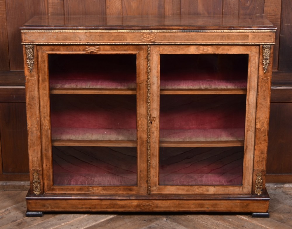A Victorian burr walnut low cabinet featuring two glazed doors, intricate boxwood inlay, and ornate bronzed corner mounts. View IV