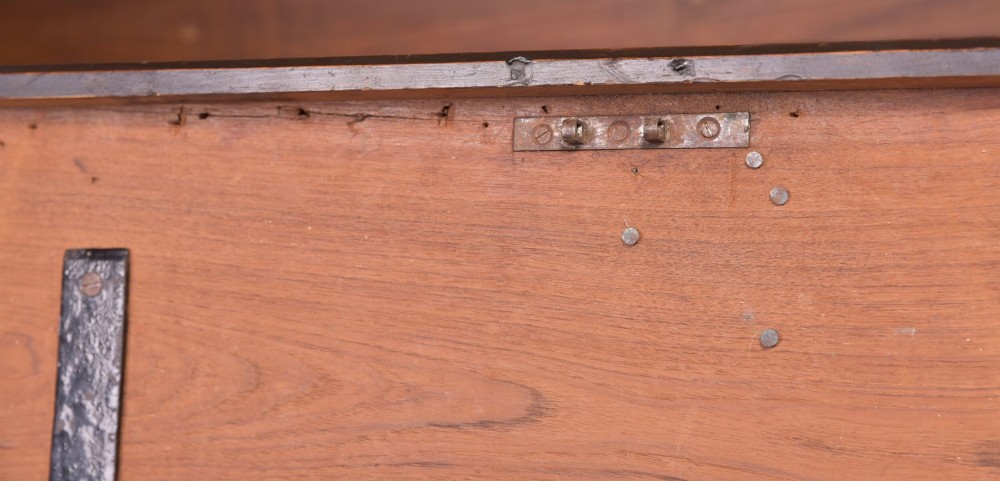 A rectangular dark brown 19th-century teak storage chest featuring heavy iron corner brackets, side handles, and a hinged flat lid. View X