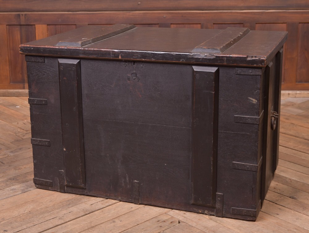 A rectangular dark brown 19th-century teak storage chest featuring heavy iron corner brackets, side handles, and a hinged flat lid. View XII
