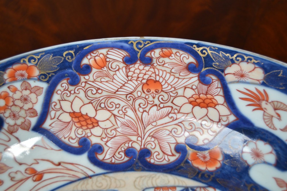 A circular Japanese Imari porcelain plate decorated in cobalt blue, iron-red, and gold floral patterns around a central floral roundel. View III