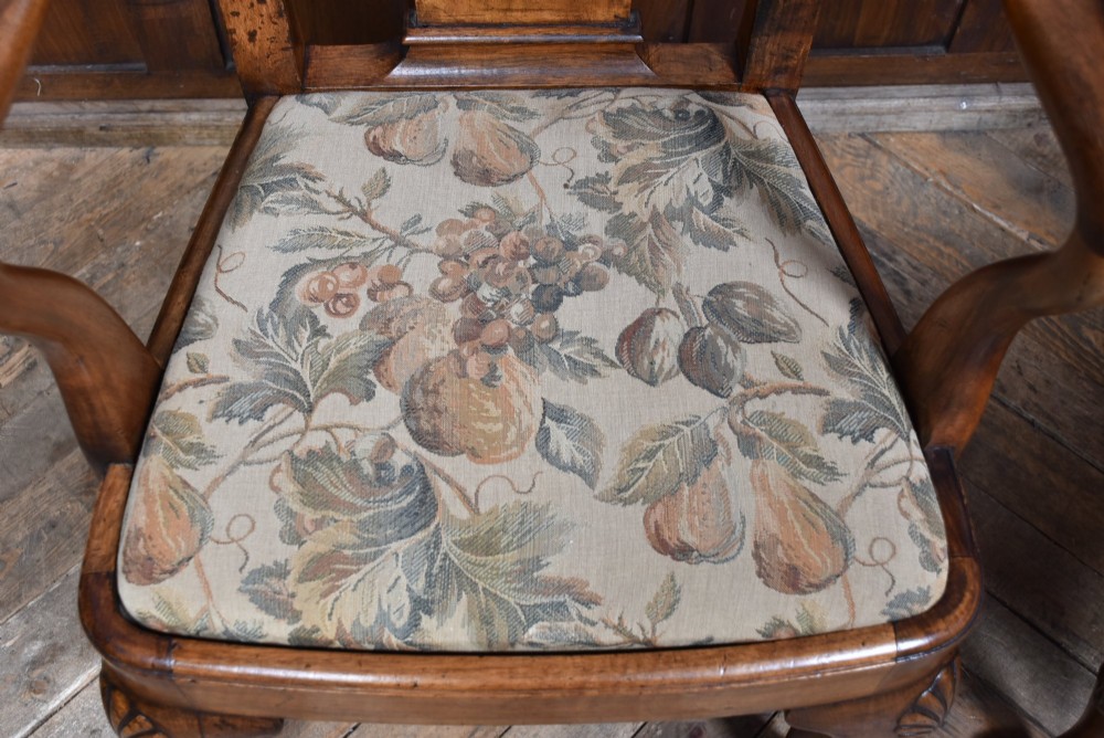 A pair of Victorian Queen Anne style walnut armchairs featuring vase-shaped back splats, carved cabriole legs, and floral patterned drop-in seats. View V