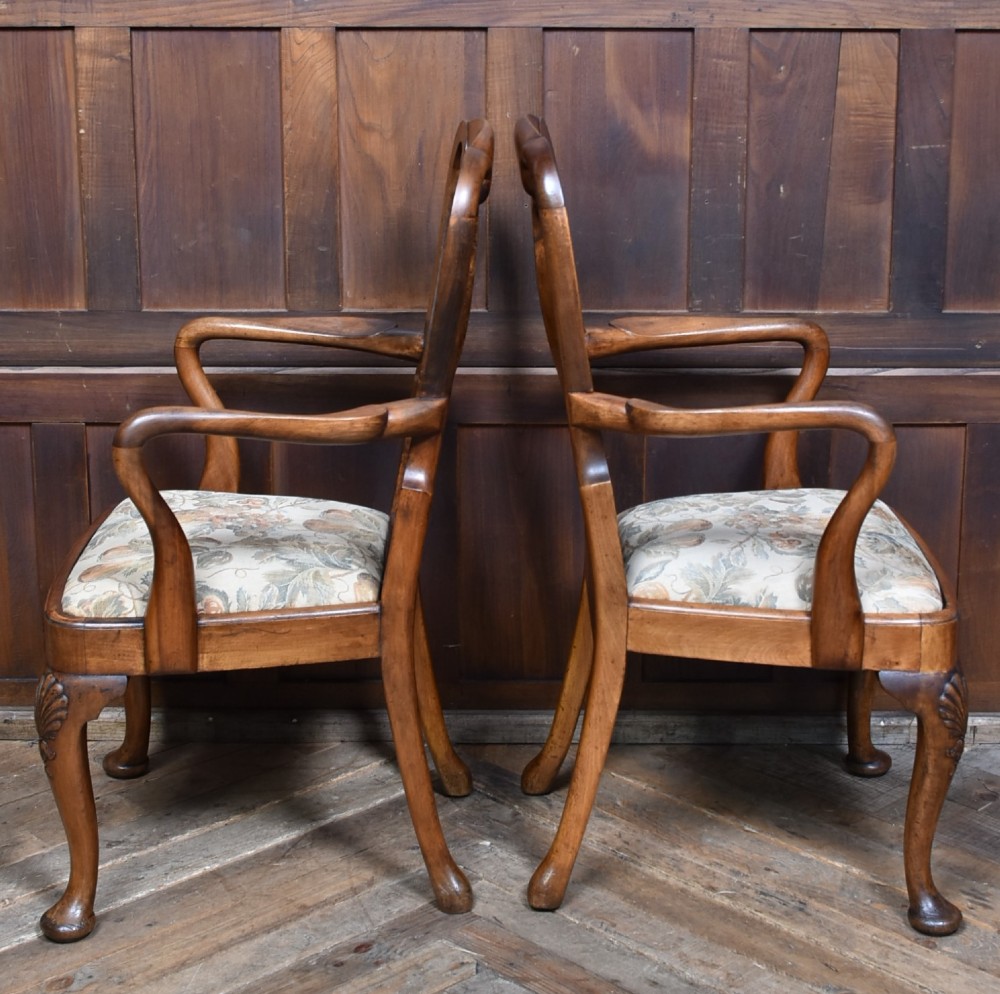 A pair of Victorian Queen Anne style walnut armchairs featuring vase-shaped back splats, carved cabriole legs, and floral patterned drop-in seats. View VII