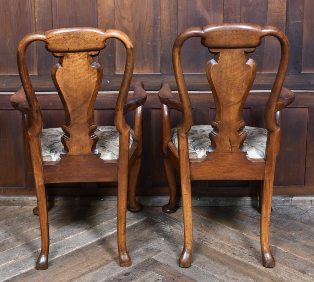 A pair of Victorian Queen Anne style walnut armchairs featuring vase-shaped back splats, carved cabriole legs, and floral patterned drop-in seats. View VIII