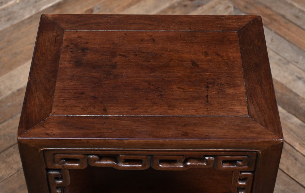 A dark hardwood Chinese vase table featuring a square top, carved fretwork apron, open lower shelf, and straight square legs. View VII
