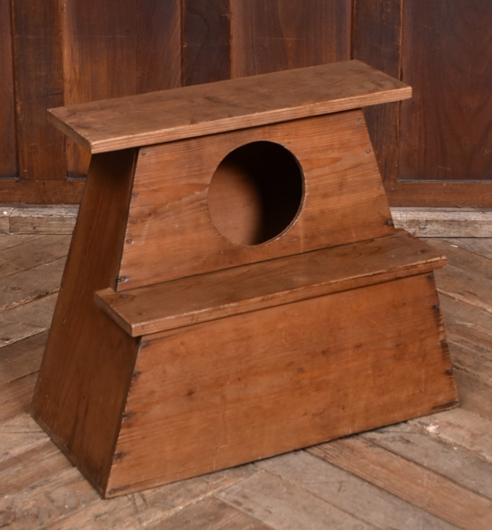A warm brown wooden Japanese vendor stool featuring a stepped rectangular base, a circular front cutout opening, and a flat upper shelf.