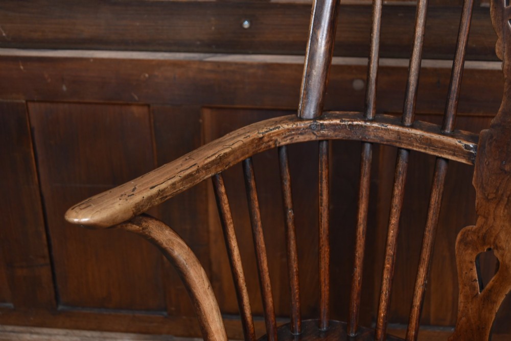 A 19th-century dark wood Windsor armchair featuring a pierced wheel back splat, spindle backrest, curved armrests, shaped seat, and turned legs. View IV