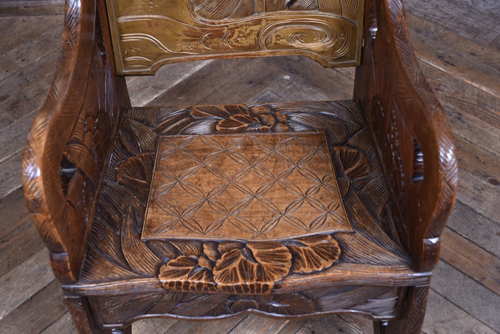 An antique carved walnut armchair featuring intricate floral relief carvings on the backrest, armrests, and legs. View IV