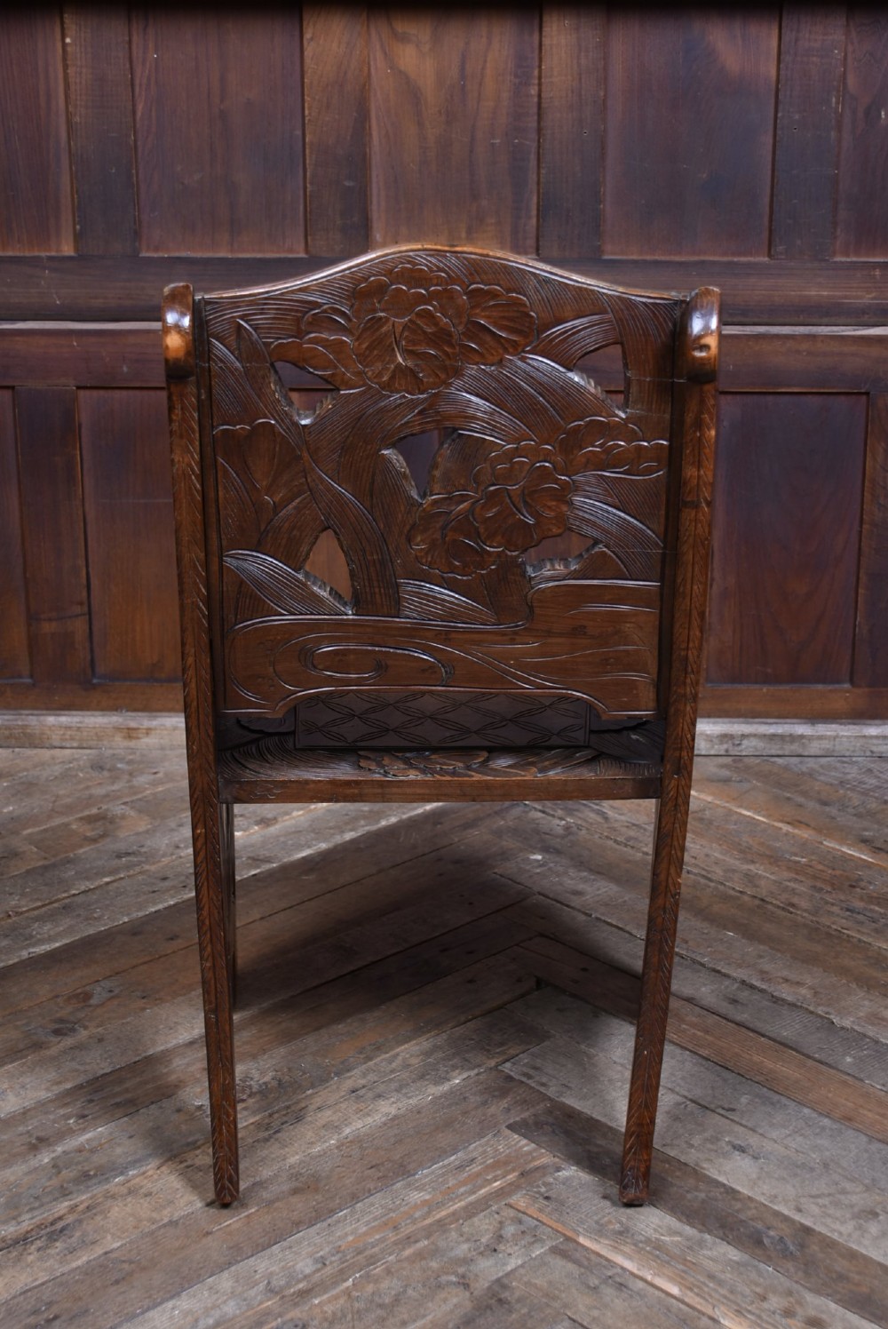An antique carved walnut armchair featuring intricate floral relief carvings on the backrest, armrests, and legs. View VIII