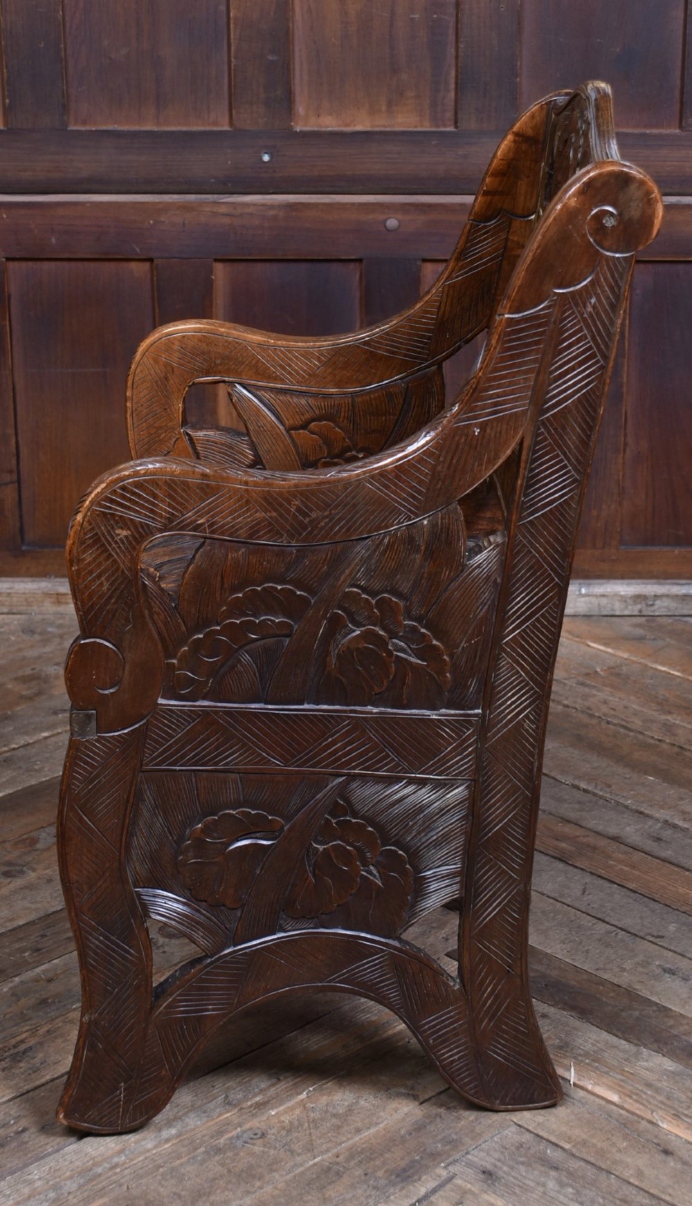 An antique carved walnut armchair featuring intricate floral relief carvings on the backrest, armrests, and legs. View IX