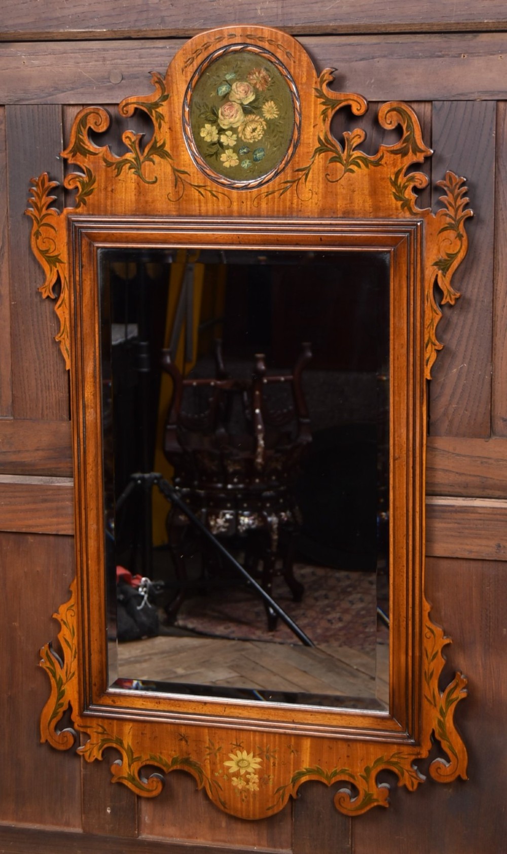An Edwardian walnut wall mirror featuring a carved fretwork border, a painted floral oval crest, and marquetry leaf scroll details framing a central rectangular glass plate. View II