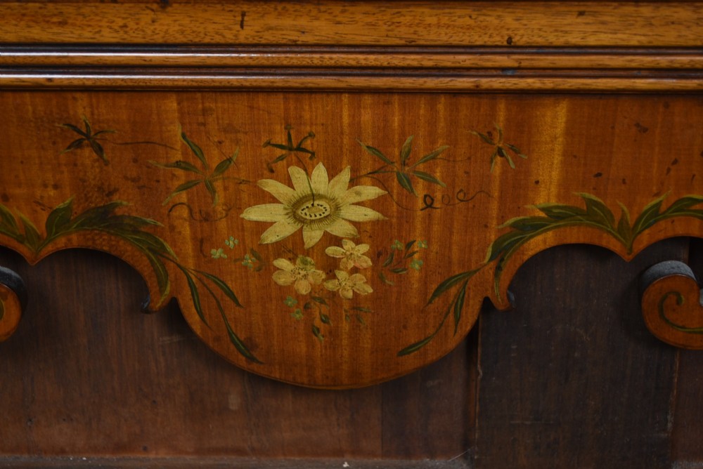An Edwardian walnut wall mirror featuring a carved fretwork border, a painted floral oval crest, and marquetry leaf scroll details framing a central rectangular glass plate. View V