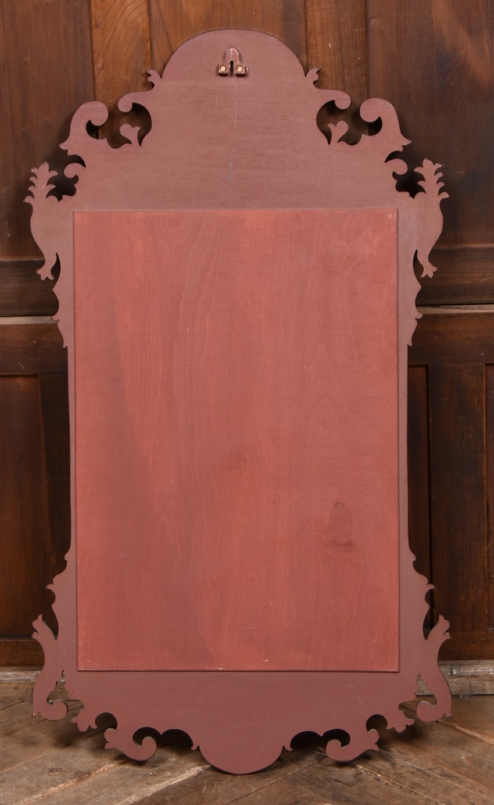 An Edwardian walnut wall mirror featuring a carved fretwork border, a painted floral oval crest, and marquetry leaf scroll details framing a central rectangular glass plate. View VII
