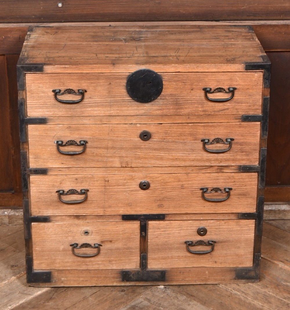 A traditional wooden Japanese tansu chest featuring four tiers of drawers accented with dark iron handles and corner brackets. View II