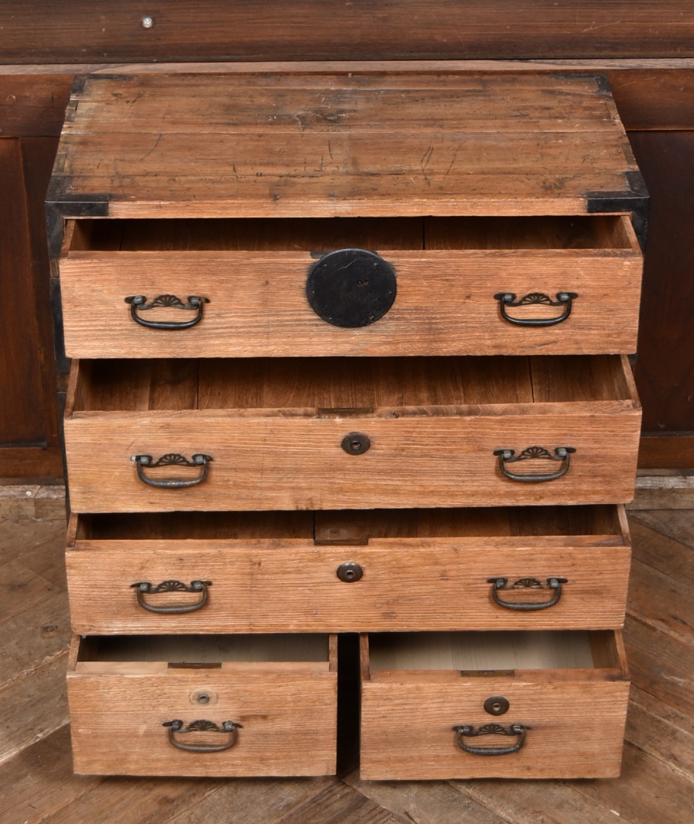 A traditional wooden Japanese tansu chest featuring four tiers of drawers accented with dark iron handles and corner brackets. View VI