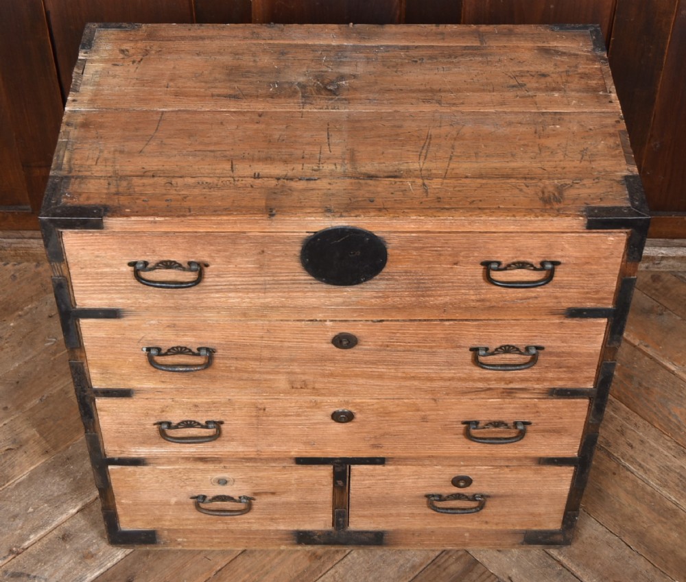 A traditional wooden Japanese tansu chest featuring four tiers of drawers accented with dark iron handles and corner brackets. View VII