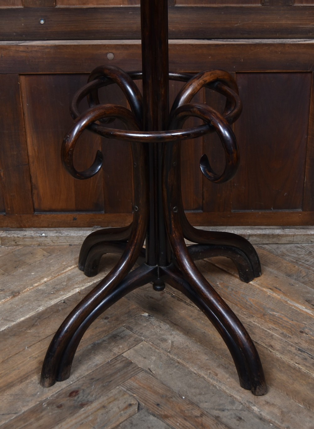 A dark brown bentwood coat and hat stand featuring curved upper hooks, an umbrella ring holder, and a splayed quadruped base. View III