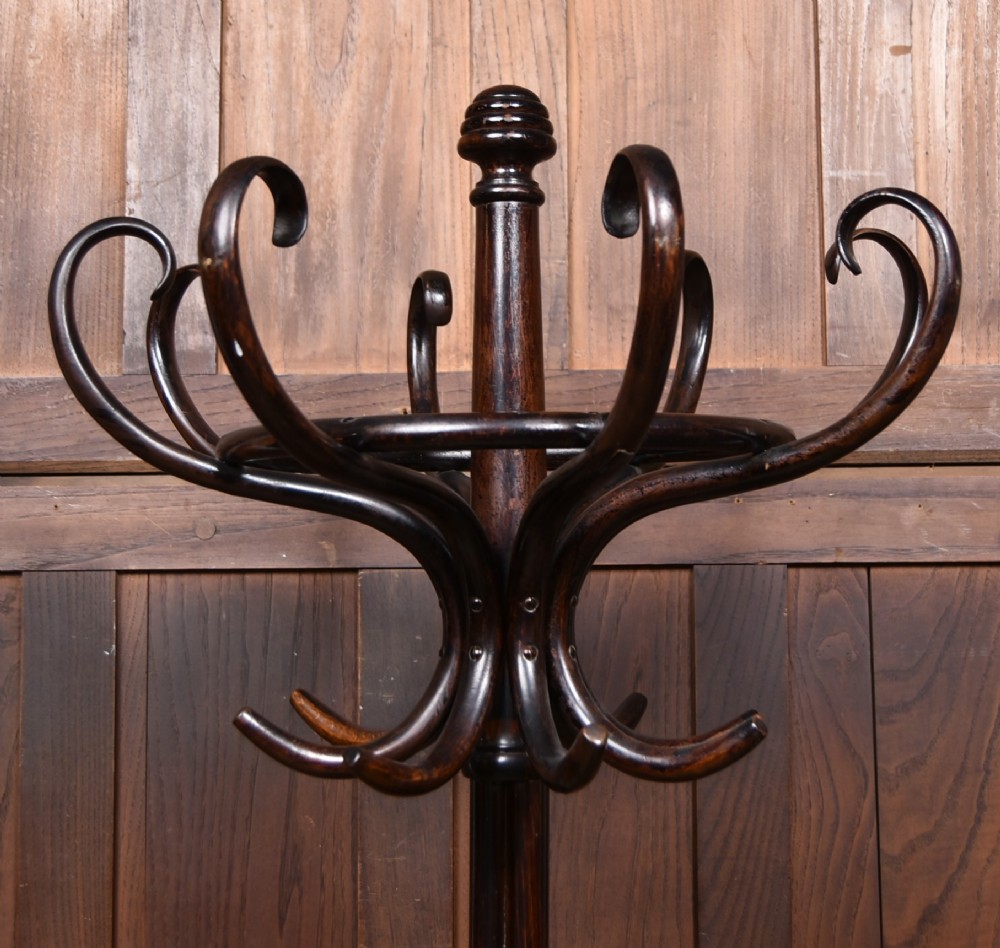 A dark brown bentwood coat and hat stand featuring curved upper hooks, an umbrella ring holder, and a splayed quadruped base. View IV