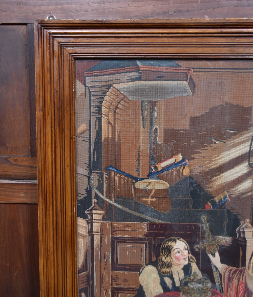 A framed needlepoint tapestry depicting figures and a crown inside an ecclesiastical interior with light streaming through a Gothic window. View V